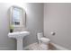 Elegant powder room featuring a pedestal sink and decorative mirror at 26879 N 100Th Ln, Peoria, AZ 85383