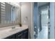 Clean bathroom with a modern vanity, mirror, and walk-in shower with shower curtain at 26879 N 100Th Ln, Peoria, AZ 85383