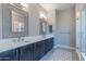 Luxurious bathroom with dual sinks, dark cabinets, and a glass shower at 26879 N 100Th Ln, Peoria, AZ 85383