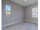 Clean and bright empty bedroom featuring light flooring and two windows with natural light at 26879 N 100Th Ln, Peoria, AZ 85383