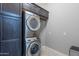 Convenient laundry room with stacked washer and dryer, plus cabinets for storage at 26879 N 100Th Ln, Peoria, AZ 85383