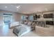 Open-concept living room featuring a sectional sofa, a kitchen island, tile floors, and access to the patio at 26879 N 100Th Ln, Peoria, AZ 85383