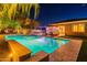 Backyard pool with travertine tile deck, patio furniture and lush landscaping at twilight at 26879 N 100Th Ln, Peoria, AZ 85383
