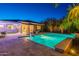 Backyard pool with travertine tile deck, patio furniture, grill and lush landscaping at twilight at 26879 N 100Th Ln, Peoria, AZ 85383