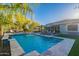 Resort style backyard featuring sparkling pool with stone waterfall, lush landscaping and comfortable seating areas at 26879 N 100Th Ln, Peoria, AZ 85383