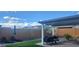 A backyard with lounge chairs, a covered patio, a grill, and artificial turf at 27636 W Runion Dr, Buckeye, AZ 85396