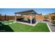 Private backyard oasis with patio, covered pergola, artificial grass, and plenty of space for outdoor entertaining at 27636 W Runion Dr, Buckeye, AZ 85396