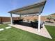 Beautiful backyard with covered patio, green grass, and desert landscaping at 27636 W Runion Dr, Buckeye, AZ 85396