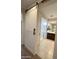 Modern bathroom featuring a stylish barn door, tiled floors, glass shower, and vanity at 27636 W Runion Dr, Buckeye, AZ 85396