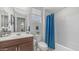 Well-lit bathroom with vanity, single sink, neutral-toned walls, and tub shower with curtain at 27636 W Runion Dr, Buckeye, AZ 85396