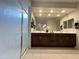 Bathroom featuring a double sink vanity, large mirror, and glass-enclosed shower at 27636 W Runion Dr, Buckeye, AZ 85396