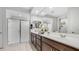 Bright bathroom featuring double sinks, spacious vanity, large mirror and glass-enclosed walk-in shower at 27636 W Runion Dr, Buckeye, AZ 85396