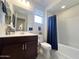 Well lit bathroom with a window, white tile backsplash, dark cabinets, and neutral colored walls at 27636 W Runion Dr, Buckeye, AZ 85396