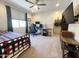Bedroom featuring carpet flooring, a ceiling fan, window, and a large mounted TV at 27636 W Runion Dr, Buckeye, AZ 85396