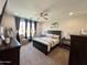 Spacious bedroom featuring dark furniture, ceiling fan, and large window at 27636 W Runion Dr, Buckeye, AZ 85396