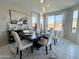 Elegant dining room featuring a large table, six chairs, and pendant lighting at 27636 W Runion Dr, Buckeye, AZ 85396