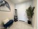 Warm and inviting entryway with stylish blue bench, art, potted plant, and tiled floor at 27636 W Runion Dr, Buckeye, AZ 85396
