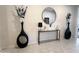 Stylishly decorated foyer featuring a black console table, decorative mirror, vases, and sleek decor at 27636 W Runion Dr, Buckeye, AZ 85396