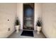 Inviting entryway with security screen door and decorative potted plants flanking the entrance at 27636 W Runion Dr, Buckeye, AZ 85396
