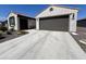 Home with a two-car garage, desert landscaping, and a concrete driveway at 27636 W Runion Dr, Buckeye, AZ 85396
