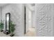 Hallway featuring artistic wall decor with an open doorway to the laundry room at 27636 W Runion Dr, Buckeye, AZ 85396