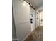Stylish hallway featuring a sliding barn door and a view into adjacent rooms with tasteful decor at 27636 W Runion Dr, Buckeye, AZ 85396