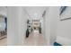 Bright hallway featuring neutral tile floors and elegant wall decor leading into the living area at 27636 W Runion Dr, Buckeye, AZ 85396