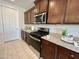 Modern kitchen features stainless steel appliances, granite counters, and dark wood cabinets at 27636 W Runion Dr, Buckeye, AZ 85396