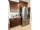 Kitchen with stainless steel refrigerator, granite countertops, and brown wood cabinets at 27636 W Runion Dr, Buckeye, AZ 85396