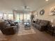 Spacious living room with dual sofas, ceiling fan, neutral paint and lots of natural light at 27636 W Runion Dr, Buckeye, AZ 85396