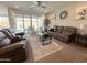 Spacious living room with comfortable seating, a ceiling fan, and a view of the backyard at 27636 W Runion Dr, Buckeye, AZ 85396