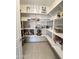 Organized walk-in pantry with white shelving fully stocked with food and drink items at 27636 W Runion Dr, Buckeye, AZ 85396