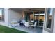 A covered patio with a hanging chair, seating area, table, and artificial turf at 27636 W Runion Dr, Buckeye, AZ 85396