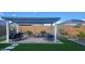 A covered patio with a seating area, grill, and artificial turf for outdoor entertaining at 27636 W Runion Dr, Buckeye, AZ 85396
