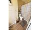 Functional bathroom with wood-look vinyl flooring, toilet, and shower behind a striped curtain at 284 W Settlers Trl, Casa Grande, AZ 85122