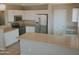 Well-lit kitchen with stainless steel refrigerator, white cabinets, and stylish countertops at 284 W Settlers Trl, Casa Grande, AZ 85122