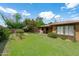 Spacious backyard with green grass, mature trees, and a covered patio at 2913 E Earll Dr, Phoenix, AZ 85016