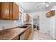 Functional kitchen featuring wood cabinets, a dishwasher, and adjacent laundry room at 2913 E Earll Dr, Phoenix, AZ 85016