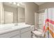 Bathroom featuring a single sink vanity with tub and shower combination and bright patterned shower curtain at 37008 N Hinterwald Way, San Tan Valley, AZ 85143