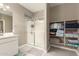Neutral bathroom with glass-enclosed shower and built-in shelving for organized towel and linen storage at 37008 N Hinterwald Way, San Tan Valley, AZ 85143