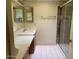 Bright bathroom featuring dual vanities, tiled floor and a glass shower door at 4107 E Bloomfield Rd, Phoenix, AZ 85032
