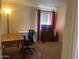 Bedroom with neutral carpet and walls, including a dresser and work desk at 4107 E Bloomfield Rd, Phoenix, AZ 85032