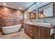 Modern bathroom featuring a soaking tub, wood accent wall, and double sink vanity with wood cabinets at 4205 N 19Th Pl, Phoenix, AZ 85016