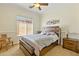 Cozy bedroom with a wooden bedframe, neutral walls and blinds on the windows at 5122 S Miller Pl, Chandler, AZ 85249