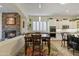 Dining area with stone fireplace, wooden table and chairs, and kitchen view at 5122 S Miller Pl, Chandler, AZ 85249