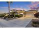 Beautiful single-story home with a three-car garage, professional landscaping and a palm tree at sunset at 5122 S Miller Pl, Chandler, AZ 85249