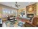 Cozy living room featuring a stone fireplace, ceiling fan, and comfortable seating at 5122 S Miller Pl, Chandler, AZ 85249