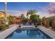 Inviting backyard pool area with lounge chairs, an umbrella-covered table, and mature tropical landscaping at 5122 S Miller Pl, Chandler, AZ 85249