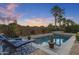 A sparkling swimming pool with lush landscaping and cozy lounge furniture at 5122 S Miller Pl, Chandler, AZ 85249