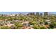 Expansive aerial view of a suburban neighborhood with lush greenery and a stunning cityscape in the background at 541 W Vernon Ave, Phoenix, AZ 85003
